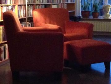 Twee oranje IKEA fauteuils met hocker