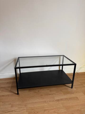 Moderne glazen salontafel met zwart metalen frame
