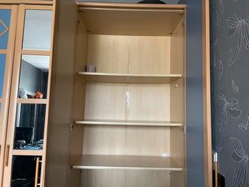 Gratis Ruime kledingkast met planken en hang gedeelte.