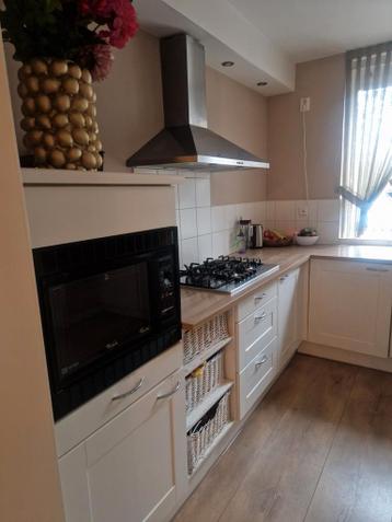 Mooie hoekkeuken met gasfornuis en afzuigkap