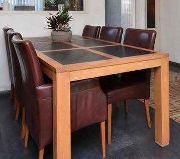 Massief eiken eettafel met ingelegde natuurstenen bladen.