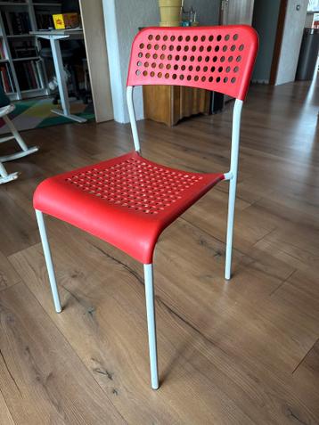 Rode kunststof stoel met metalen poten
