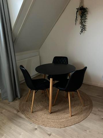 Ronde zwart met licht houten eettafel met drie stoelen