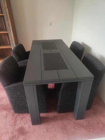 Eetkamer tafel met 4 stoffen stoelen.