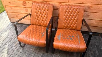 Twee lederen stoelen met armleuning