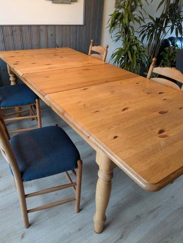Uittrekbare houten eettafel met 6 bijpassende stoelen.