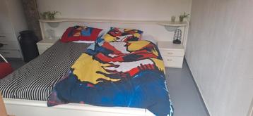 Tweepersoonsbed met ombouw en nachtkastjes