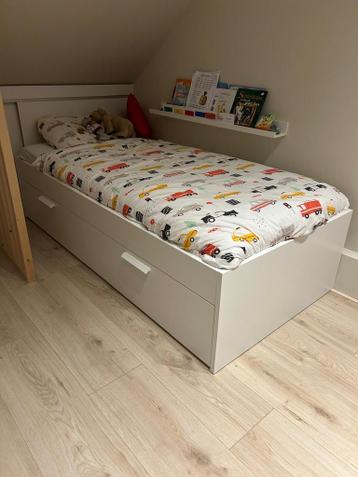 Wit eenpersoonsbed met opberglades