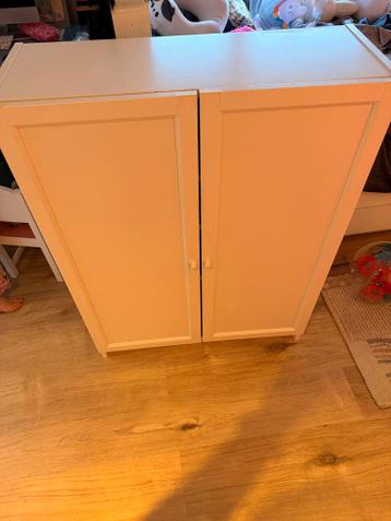 Witte kast met deurtjes en planken