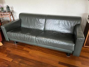 Donkergroene leren bank.