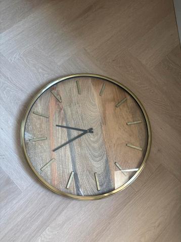 Grote wandklok met gouden rand en houten binnenkant