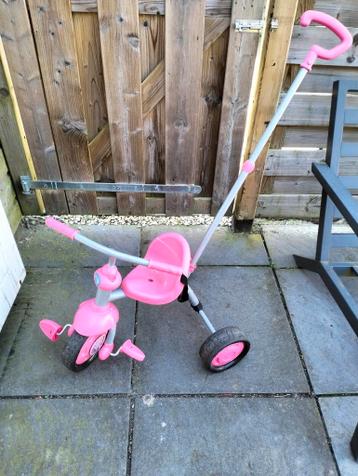 Roze driewieler met duwstang