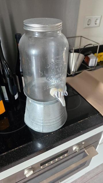 Glazen drankdispenser met tapkraan en metalen voet