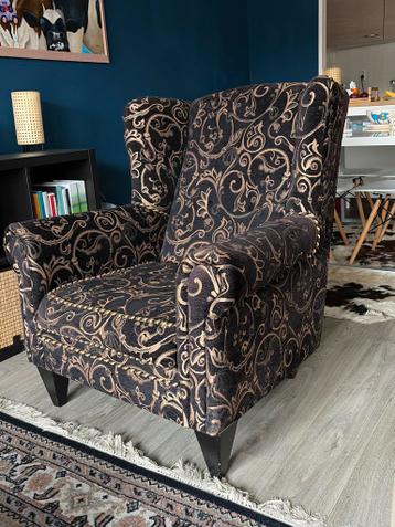 Stijlvolle fauteuil met goudkleurig patroon.