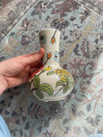 Kleine vaas met bloemen en vlinders