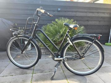 Zwarte damesfiets met voordrager en bagagedrager