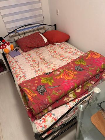 Tweepersoonsbed met metalen frame en bloemenbeddengoed