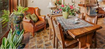 Oud Perzisch tafelkleed iets beschadigd onder de vaas