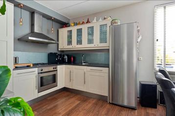 Gebruikte hoekkeuken met inbouwapparatuur en kasten