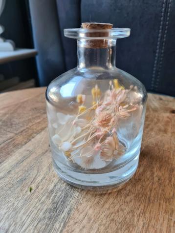 Flesje met droogbloemen erin