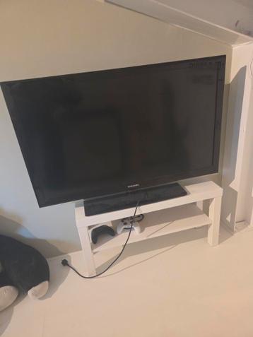 Samsung tv met afstandsbediening en een ikea kastje