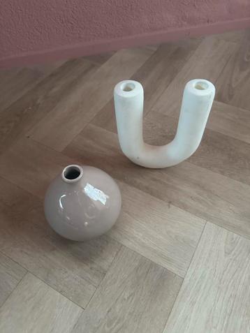 Witte U-vormige kaarsenhouder en beige rond vaasje