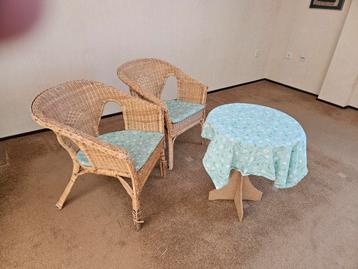 Twee rotan stoelen met kussens en bijzettafel