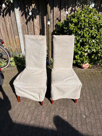 Twee eetkamerstoelen met stoffen hoezen