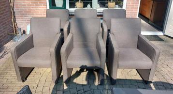 Zes bruine stoelen met armleuningen