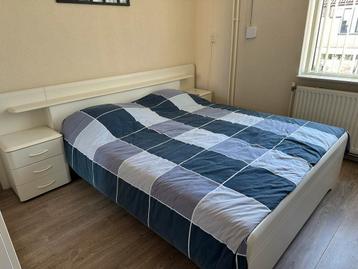 Tweepersoonsbed met nachtkastjes en verlichting