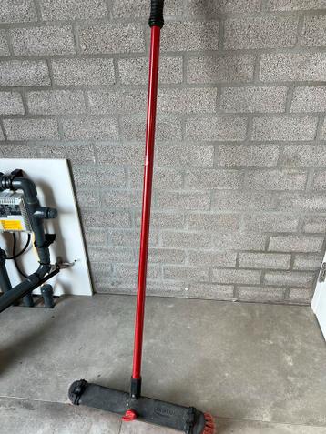 Harde bezem met rode steel