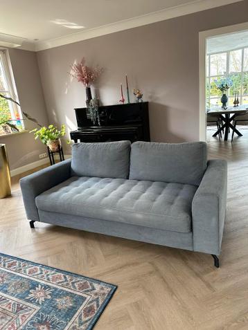 Grijs blauwe bank met twee rugkussens