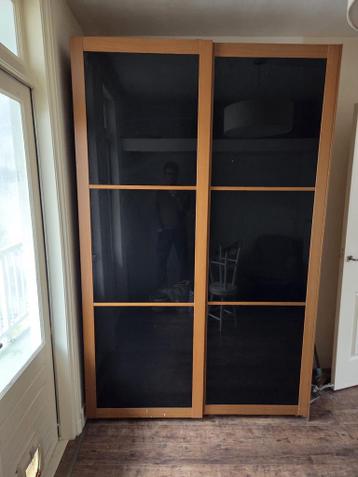 Ruime kledingkast met schuifdeuren en glas