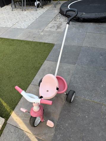Roze driewieler met duwstang