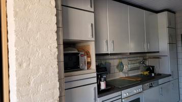 Keuken met boven- en onderkasten, koelkast.