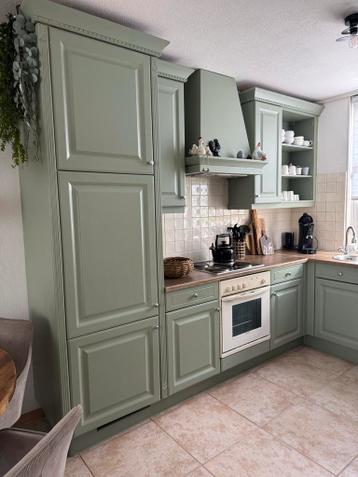 Groene hoekkeuken met bovenkasten