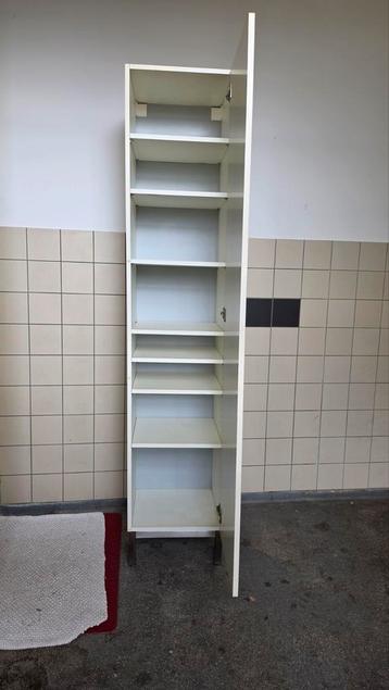 Hoge witte kast met planken en deur