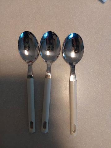 Drie lepels met witte handvatten