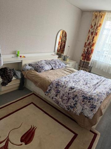 Tweepersoonsbed met hoofdbord en nachtkastjes