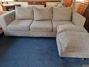 Stoffen bankje met losse kussens.