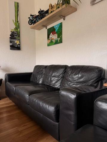 Twee zwarte driezitsbanken nepleer