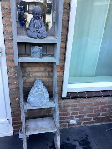 Twee Boeddhabeelden op houten ladderrek