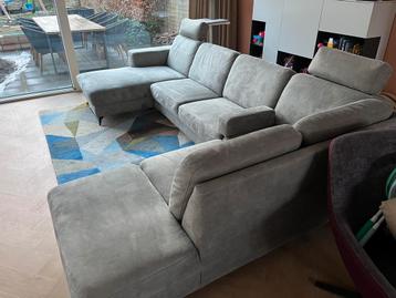 Grijze bank bekleed met combinatie van leer en textiel.