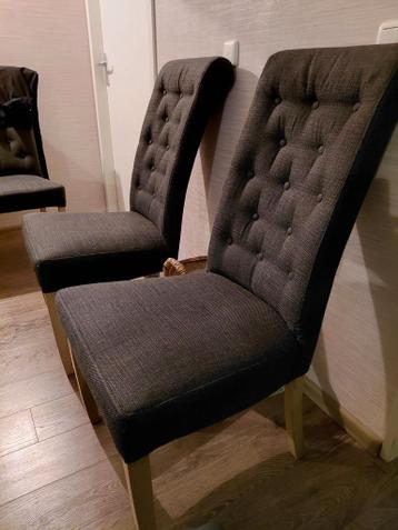Vier donkergrijze eetkamerstoelen met knopen