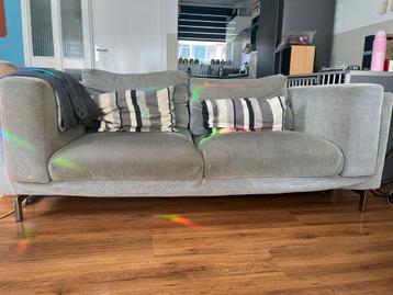 Grijze tweezitsbank met metalen poten