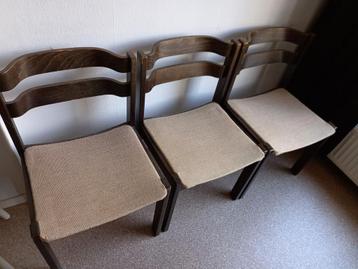 Drie houten stoelen met stoffen zitting