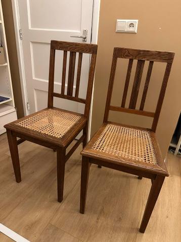 Twee houten stoelen met gevlochten zittingen