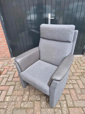 Grijze fauteuil met leren armleuningen