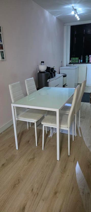 Glazen eettafel met 4 witte leren stoelen