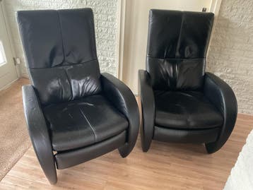 Zwarte leren fauteuils, 1 is handmatig verstelbaar